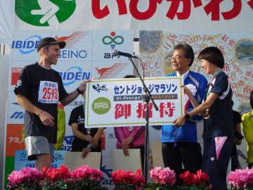 表彰式の様子（男子優秀選手ザック市長代理から、来年のSt.Gマラソンへ招待状）
